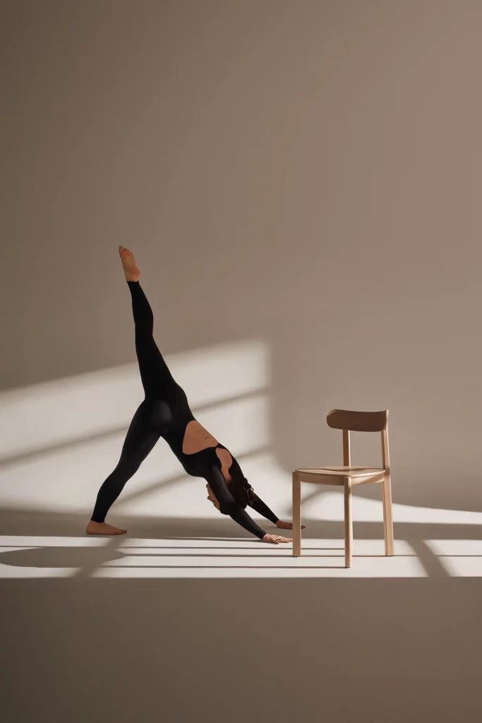 haciendo yoga interactuando con mobiliario de marca de diseño
